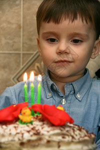 3岁的天主教男孩庆祝生日和在蛋糕上吹蜡烛以庆祝他的生日幸福男微笑图片