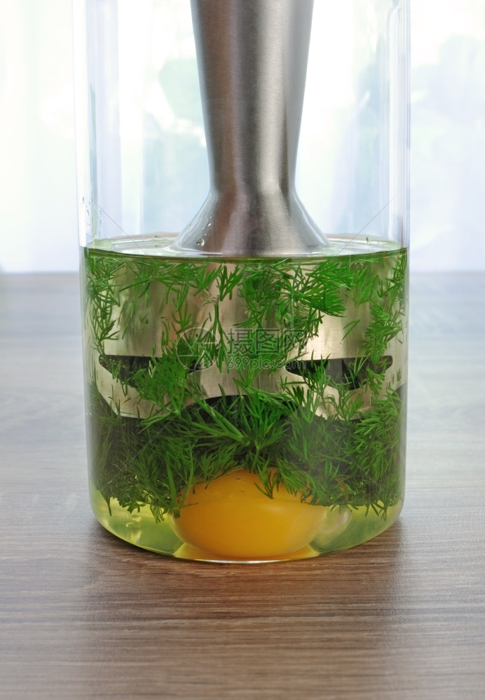 填充橄榄油蛋黄在杯子里浸泡的搅拌机来准备奶油酱食物蛋黄图片