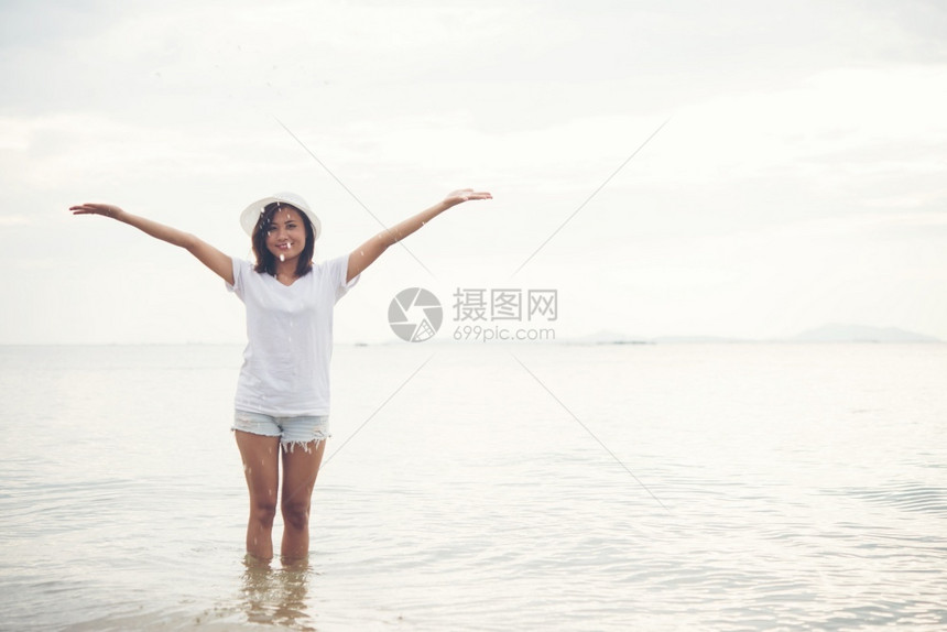 白色的快乐年轻女子在度假时间海滩上玩自然愉快图片
