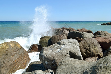 波浪自然在希腊卡马里海滩的岩石上喷洒海水流横冲直撞地平线图片