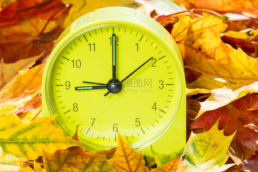 秋天的闹钟时间改变概念在秋天我们一小时前改变钟分有色匆忙图片