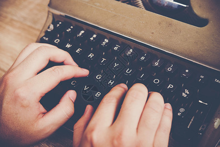 编辑键盘老的手打在木制桌上的老式打字机图片