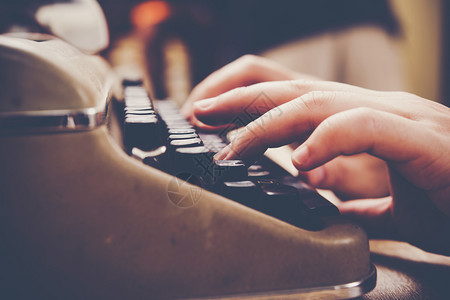 黑色的写机器手打在木制桌上的老式打字机图片