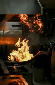 美食手火炉锅里拿着的煮饭和从里冒出的火焰图片