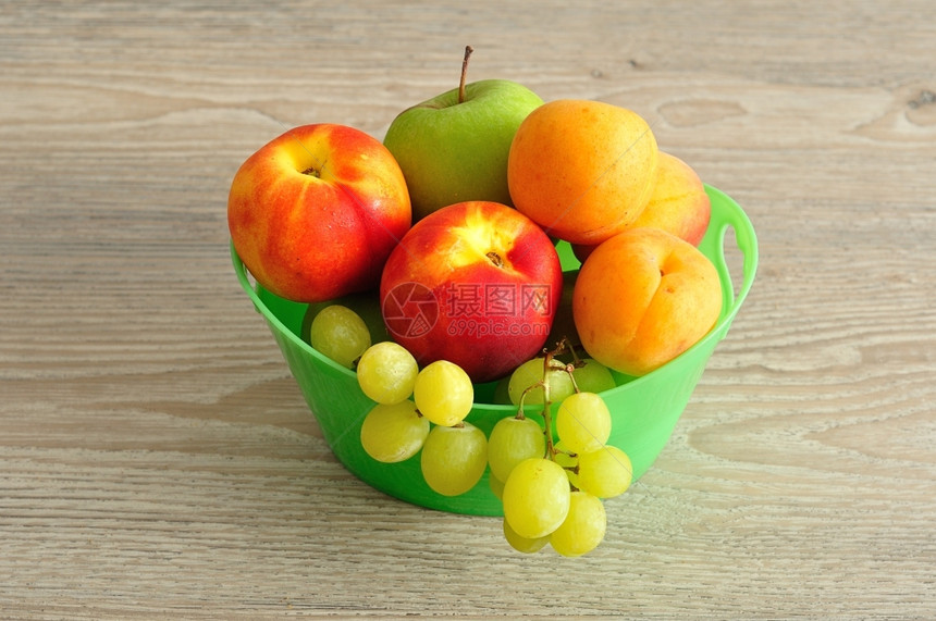 一种有机的绿色塑料桶中各种水果的品食物图片