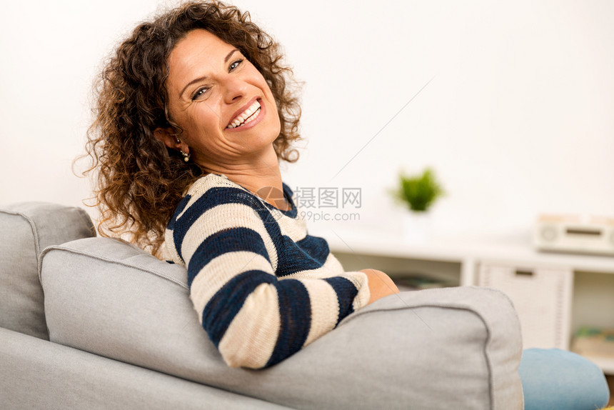 坐在沙发上家里美丽的幸福女人图片