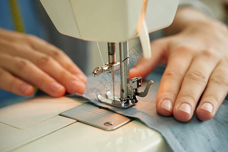 工作时使用缝纫机裁的女手掌织物创造力工作室图片