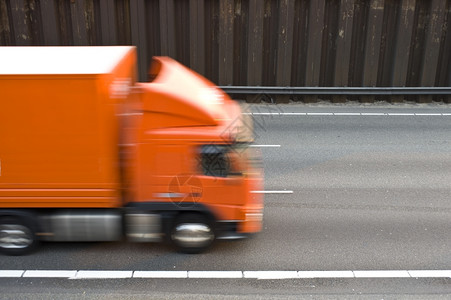沟一条多道高速公路有线条和沥青一辆橙色卡车驶过该公路桩安全背景图片