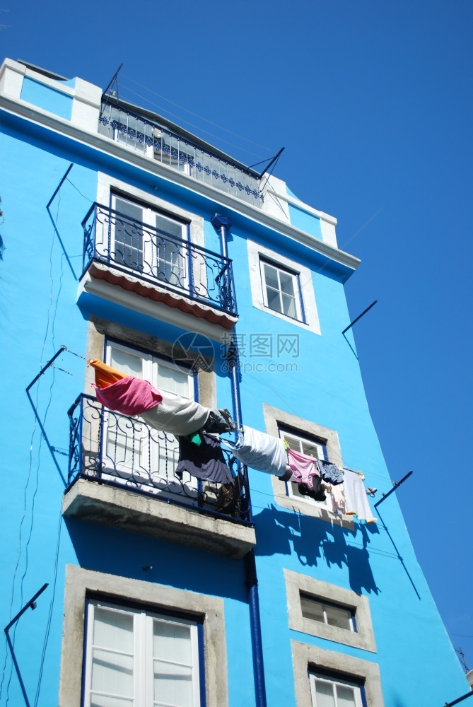 蓝色传统建筑窗边晾晒的衣物图片