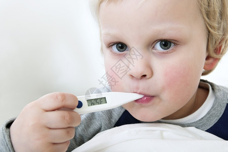 孩子金发流感一名幼儿的嘴里有一个温度计测量其发烧情况他的肖像图片