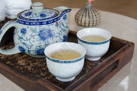 亚洲人白色的茶壶和杯放在桌上图片