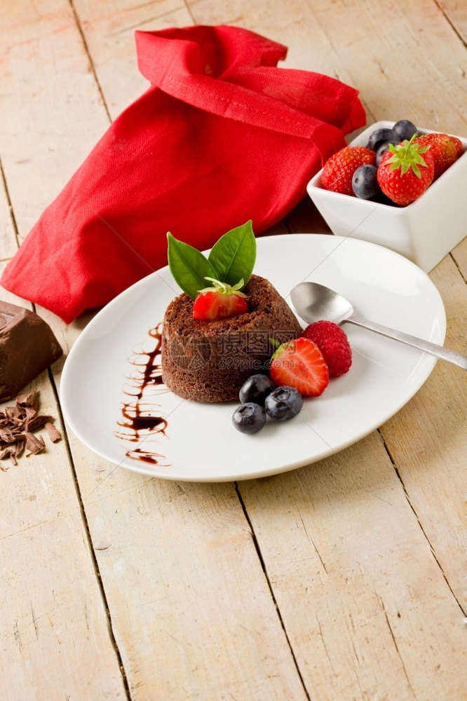 照片美味巧克力甜点木制桌上有浆果树叶草莓木制的图片