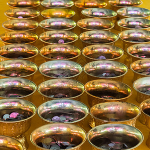 东方的在泰国寺庙用小硬币为慈善事业献金盘踏板托目的图片