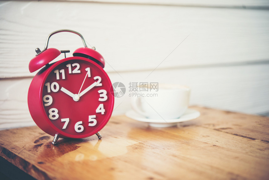 桌上的咖啡和红色闹钟图片