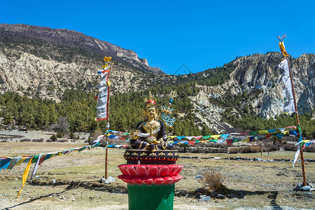 旅行文化在尼泊尔Braka村的Sunny日一个明亮的佛教雕像徒步旅行图片