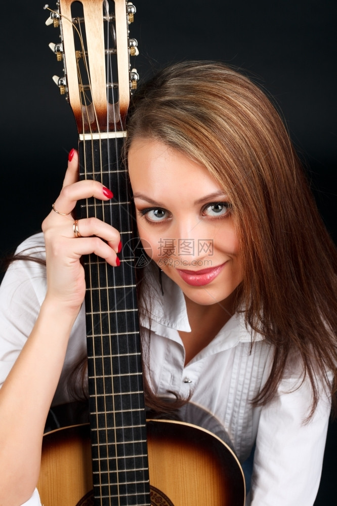 一个年轻有魅力的女人肖像带着黑色背景的吉他美丽成人白种图片