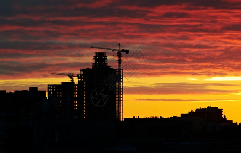 高的城市景观轮廓日落时正在建造的休风起重机图片