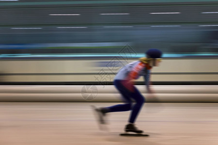 运动室内的女孩在滑冰的竞赛速度中在室内滑冰的女孩背景图片