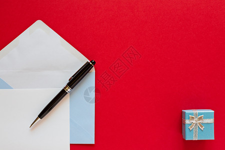 红色背景上的圣诞信和笔红色背景上的圣诞信纸盒子一种图片