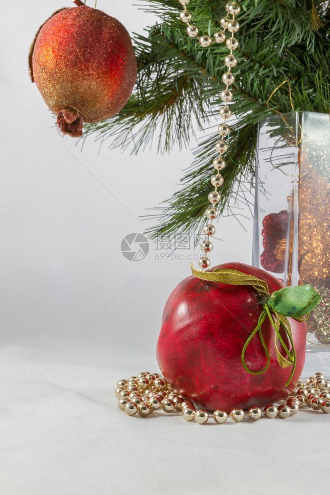 圣诞树枝和花瓶中的装饰包括人工石榴和苹果以及绿色装饰风格假期图片