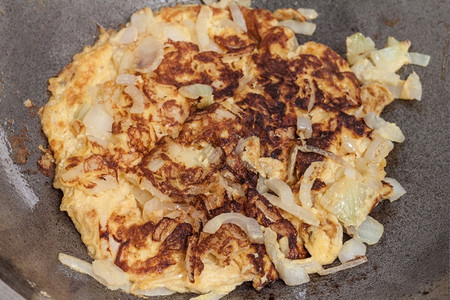 锅里加热油的煎蛋卷和洋葱菜单蔬晚餐图片