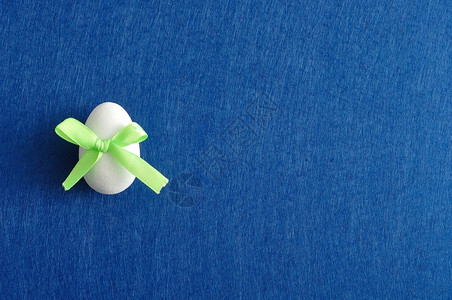 季节四月以蓝背景隔离的绿色弓形东面鸡蛋壳设计图片