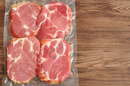 包装好的健康木制背景上展示的真空包装肉美食背景图片