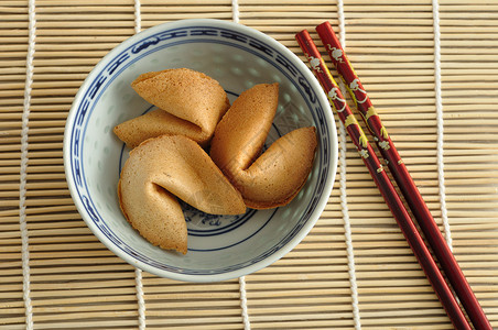 财富饼干在碗里红筷子与勺隔离在色背景上白的运气曲奇饼图片