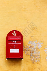 黄色墙上的红达尼信箱黄的交货建造图片