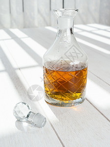 常设饮料站在白木桌上的老威士忌脱脂酒水晶高清图片