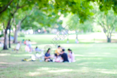 家庭闲暇自行车Bokeh灯光春季和夏的公园中人们活动背景模糊的背景图片