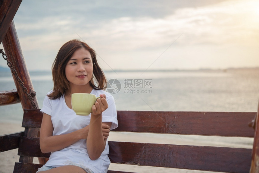 海滩度假喝咖啡的美丽女孩图片