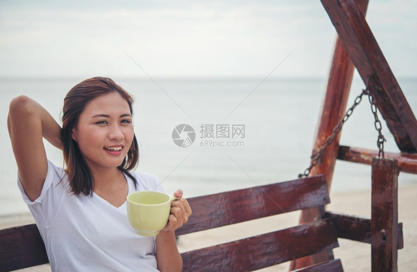 海滩度假喝咖啡的美丽女孩图片