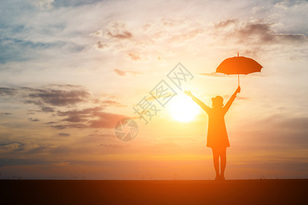 成人女在海滩和日落上拿着雨伞的月光生活运动图片