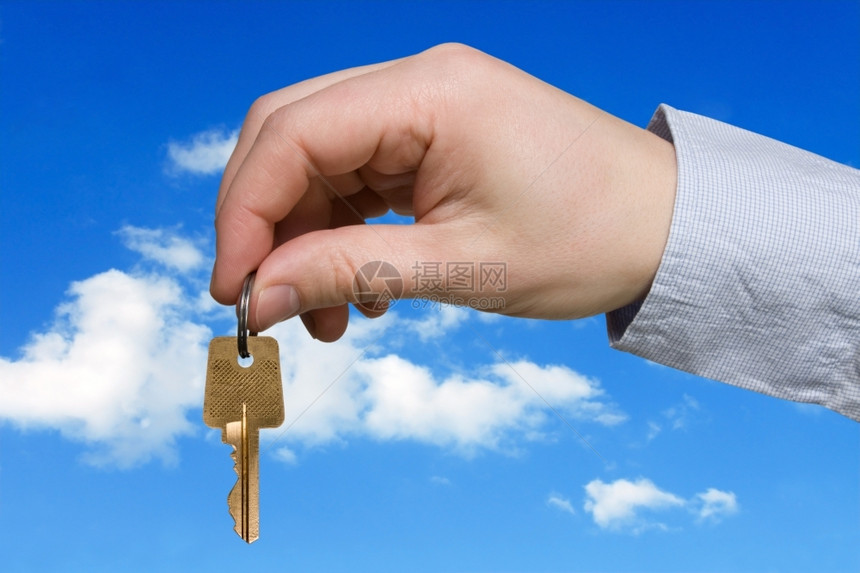 蓝色天空背景上带有密钥的手键租安全商人图片