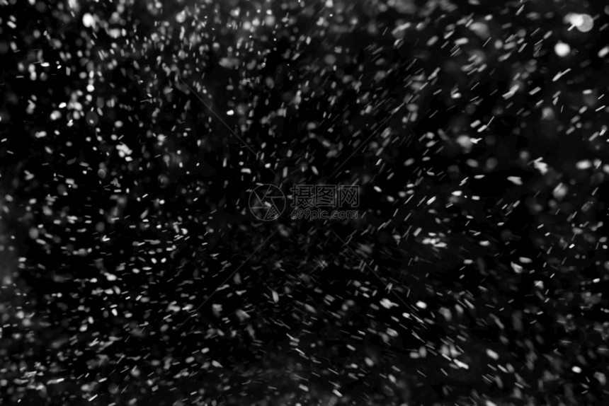 抽象的在黑色背景上飘落的雪花在黑色背景上飘落的雪花假期霜图片