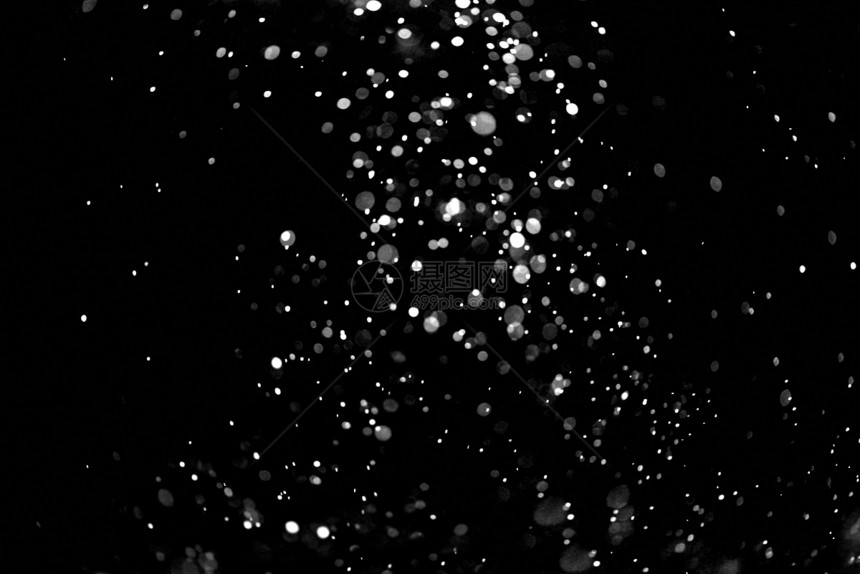 在黑色背景上飘落的雪花在黑色背景上飘落的雪花圣诞节明亮的质地图片