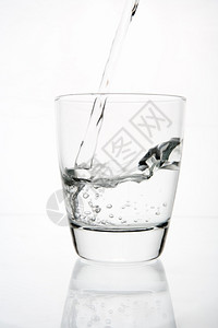 气泡健康将水倒入清玻璃杯背光图片