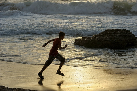 沿着男孩在以色列地中海岸上奔跑与地中海接壤滴跑步图片