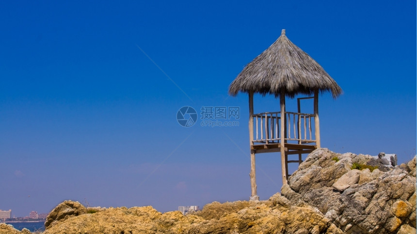 站在岩石海滩附近的木头守望塔海岸洋靠近图片