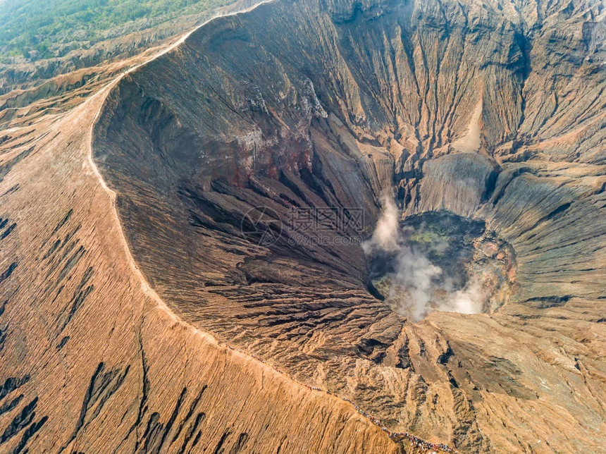 印度尼西亚爪哇岛活火山Bromo空中观赏火山口和许多游客在活火山航空观的喀德拉克特和卡尔德上看到火山口喷发抽烟蒸汽图片