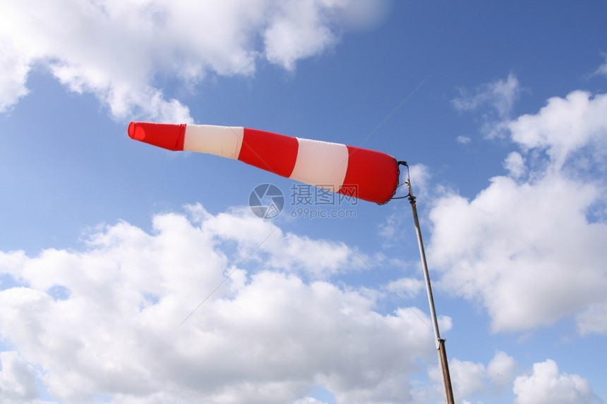 风船旗红色和白条纹于蓝天空背景的红白条纹于蓝色天空背景的风船旗向袋袖子白色的图片
