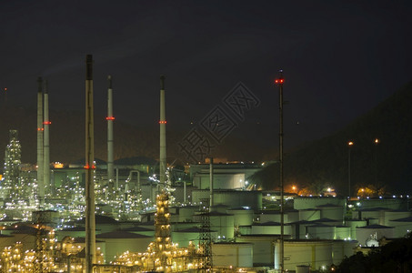 大油罐和烟囱高地晚上的炼油厂大罐燃料建筑学图片