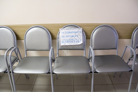 公告医疗的空走廊内带有随附便条的一排椅子随附图片