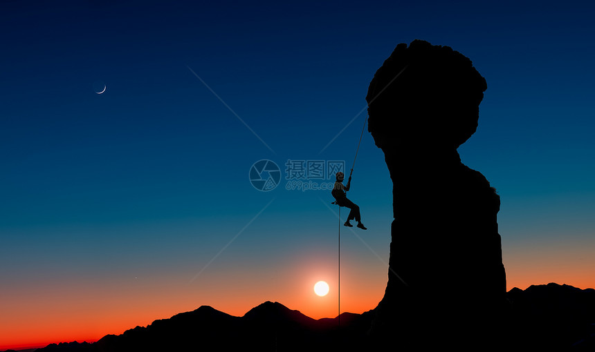 安全一个登山者在日落时爬上山后独自从一个岩峰上飞来攀登顶图片