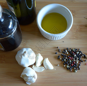 调味料小模子一份拉面盘里含橄榄油一瓶温和醋大蒜木板上的胡椒粒图片