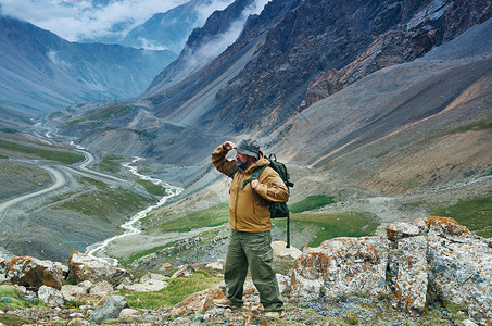 徒步旅行带着背包徒步远足到中亚山顶的天主教男子人们图片