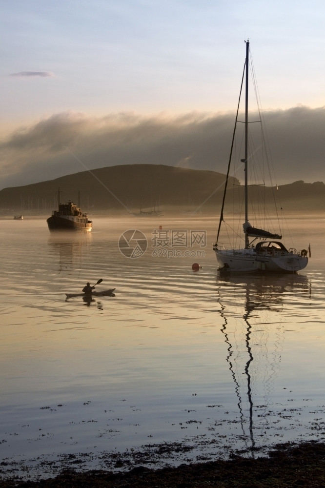 独木舟苏格兰人船清晨在苏格兰西海岸Oban港口上空喷起大雾图片