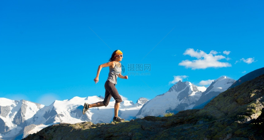 天跑阿尔卑斯山夏天女孩在高上跑来去其背景是冰川训练图片