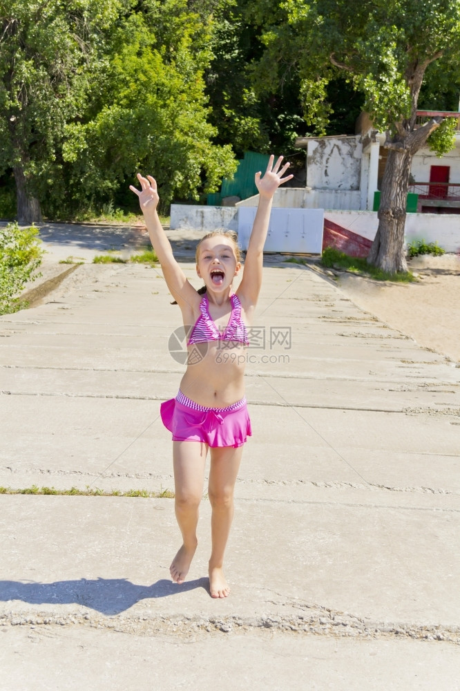 身穿粉红色泳衣在河岸边玩耍的小女孩图片